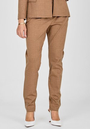 Brah v črte hlače iz teksturirane tkanine, ki imajo prilegajoč kroj in zožen dizajn nog, v kombinaciji z belimi visokimi petkami.