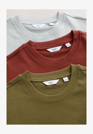 Drei Crew-Neck-T-Shirts gestapelt: hellgrau, Rost und Olivgrün. Jedes hat einen gerippten Kragen und Etiketten mit Marken- und Größenangabe.