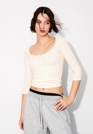 Bershka, LONG-SLEEVE V-NECK SHIRT WITH LACE DETAIL AND BUTTONS - T-shirt à manches longues - beige
