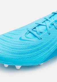 Scarpa da calcio azzurra chiara con superficie testurizzata, motivi intricati e tacchetti bianchi. Include lacci blu abbinati e dettagli.