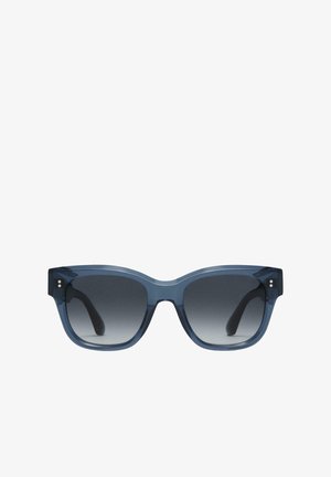 Blue transparent acetate sunglasses with a bold cat-eye shape and gradient gray lenses; features glossy finish and small metal accents.
