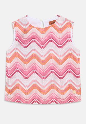 Haut sans manches avec un motif en zigzag dans des teintes de rose, orange et blanc. Fabriqué en tissu texturé avec une fermeture à boutons à l'arrière.