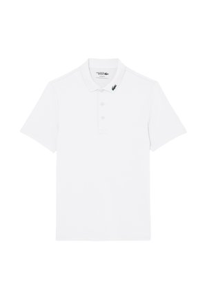 Weißes Poloshirt mit kurzen Ärmeln, Kragen und drei Knöpfen, mit einem kleinen grünen Krokodil-Logo auf der linken Kragenspitze.