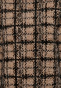 Tissu en laine à motif à carreaux marron clair et noir avec des carrés distincts, une texture douce et une légère duvreté sur toute la surface.