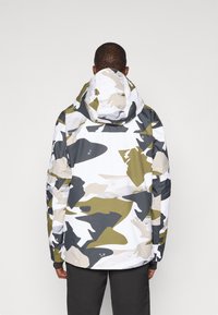 Vízálló dzseki fehér színben, zöld, szürke és bézs árnyalatú camo mintával. Kapucnival és laza szabással rendelkezik.