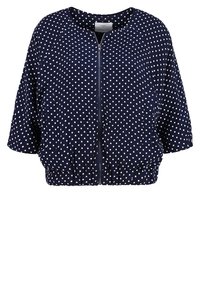 Veste courte bleu marine à pois blancs, fermeture éclair devant, encolure ronde et manches trois-quarts.