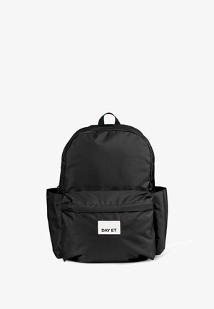Schwarzer Rucksack mit zwei Fächern, Vordertasche mit einem weißen Etikett, auf dem "DAY ET" steht, und einem grünen Tragegriff oben.