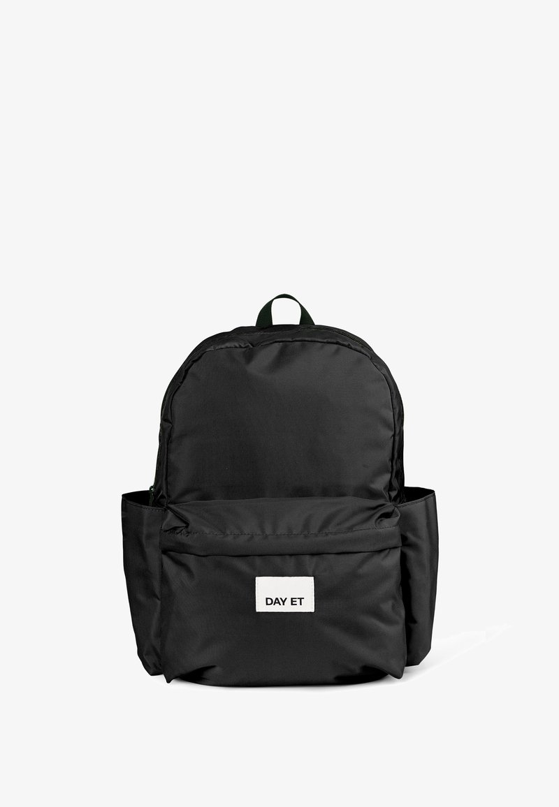 Sac à dos noir avec deux compartiments, poche avant arborant une étiquette blanche indiquant "DAY ET," et une poignée de transport verte sur le dessus.
