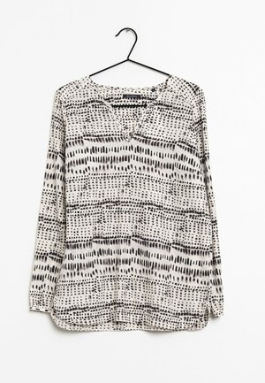 Langærmet, v-hals bluse i hvid med sort abstrakt mønster. Letvægtsmateriale, lige snit, med sidelommer og afslappet pasform.