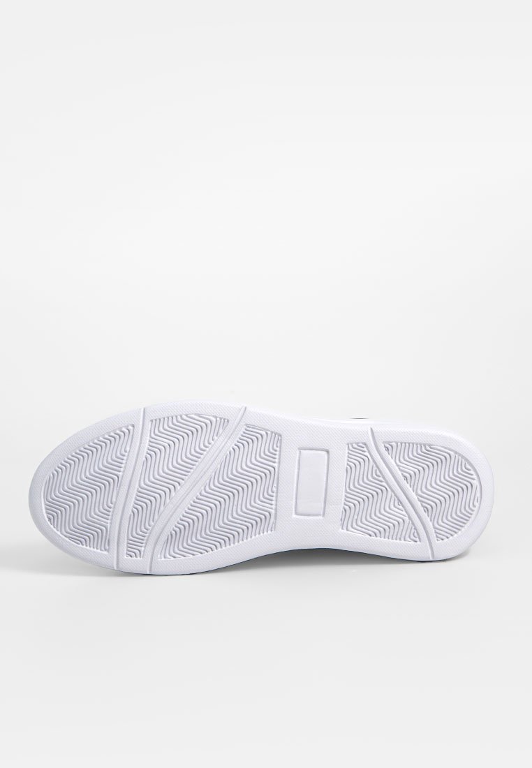 Suela de zapatilla blanca con un patrón de espiga, textura suave y un panel central ligeramente elevado. Diseñada para un agarre y estabilidad óptimos.