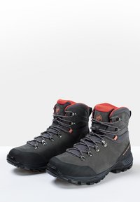 Bottines de randonnée en cuir et textile gris foncé avec des accents rouges. Dotées de crochets en métal et de semelles texturées pour une meilleure adhérence. Design offrant un bon maintien de la cheville.