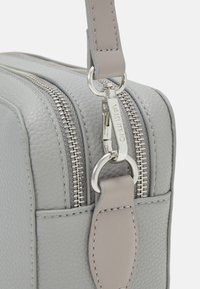 Borsa in pelle grigia con finitura testurizzata, doppie cerniere argentate e tracolla abbinata. Presenta un dettaglio argentato con il logo.