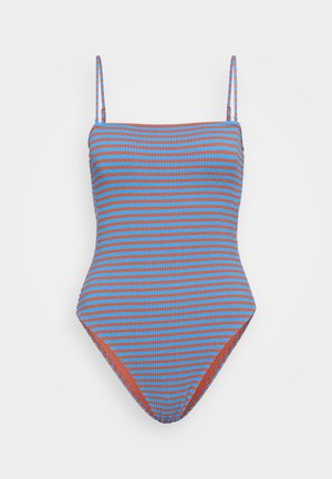 Yhdisteasukku, jossa on ohuet hihnat ja sinivalkoinen ja oranssi raidallinen kuvio. Valmistettu tekstuurikankaasta, jossa on matala selkädesign.