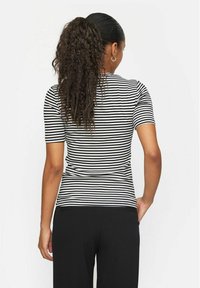 Zwart-wit gestreepte short-sleeve top, aansluitende silhouet, gladde textuur, ronde halslijn, gedragen met zwarte broek.