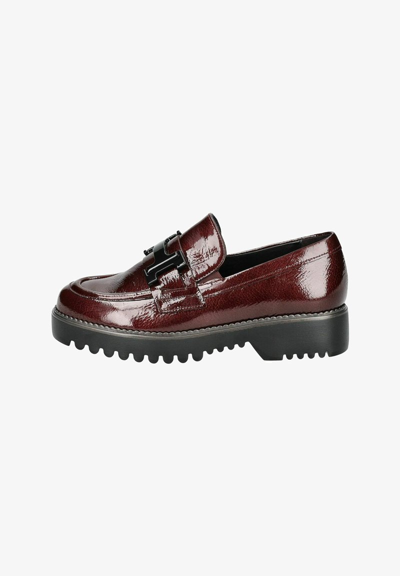 Mocassino in pelle verniciata bordeaux con suola piatta nera texturizzata e dettagli decorativi in metallo nero sulla parte superiore.
