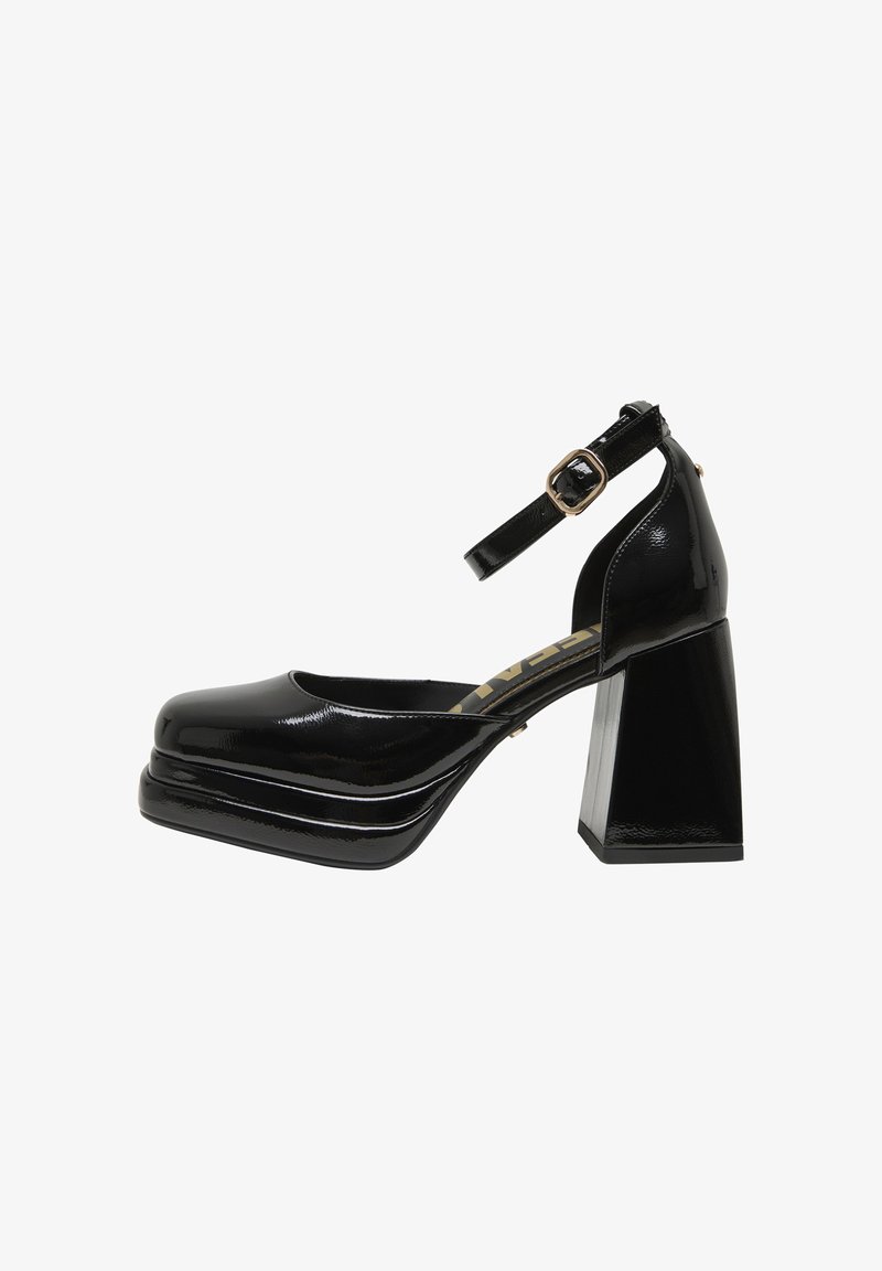 Chaussure pour femme en cuir verni noir avec talon bloc épais, bout carré et bride de cheville réglable avec boucle dorée.