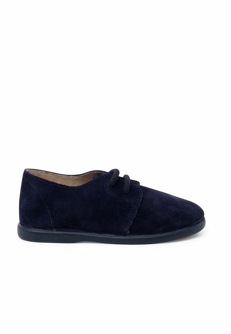 Pantofii din suede bleumarin au un vârf rotund, două găuri pentru șireturi și o talpă plată din cauciuc negru, având un exterior texturat și fără modele vizibile.