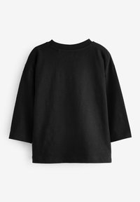 Haut noir à manches longues en tissu doux. Il présente un col rond et une coupe loose avec des épaules légèrement tombantes. Aucun motif ou ornement visible.