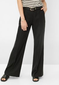 Black wide-leg trousers made of lightweight fabric, featuring a smooth texture and a high waist with a gold-accented black belt.