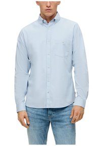 Camicia azzurra chiara a maniche lunghe con colletto button-down, tasca frontale, polo anteriore e polso con un bottone. Realizzata in un tessuto morbido e liscio.