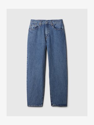 Vaaleansiniset farkut suoraan lahkeilla, viisi taskua, edessä napitus ja näkyvät ompeluyksityiskohdat. Rakoileva kangas.