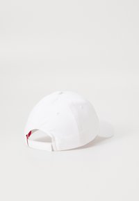 White baseball cap with a curved brim, adjustable strap at the back, and fabric texture. No visible logos or patterns.