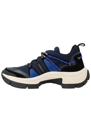 Granatowo-czarny sneaker z grubą białą podeszwą, niebieskimi akcentami, siateczkowymi i zamszowymi materiałami oraz pętelką na pięcie.
