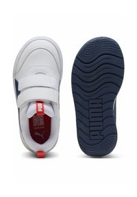 Baskets de sport blanches et navy avec un dessus en synthétique lisse, des brides Velcro et une semelle en caoutchouc texturé arborant un logo "PUMA" bien en vue.