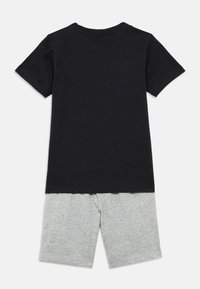 Μαύρο βαμβακερό T-shirt με κοντά μανίκια και στρογγυλή λαιμόκοψη, σε συνδυασμό με ανοιχτό γκρι βαμβακερά σορτς, με απλό σχέδιο και απαλή υφή.