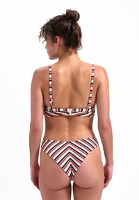 Ensemble de bikini rayé avec fermeture à l'arrière, fines bretelles, rayures rouges, blanches et bleu marine en motif en chevrons, fabriqué à partir d'un matériau de maillot de bain lisse.