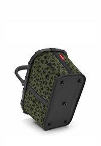 Cesta verde con patrón de leopardo, con un exterior texturizado y esponjoso, y un marco y base de plástico negro. Presenta un mango resistente para llevarla.