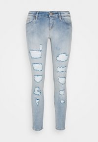 Ljusblå skinny jeans i denim med slitna lappar och revor. Tajt passform med standard midja och manschetter.