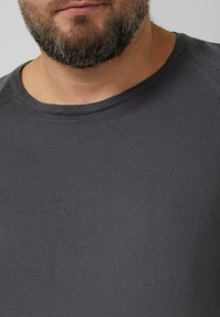 Grafitowy prążkowany sweter z okrągłym dekoltem, wykonany z teksturowanej tkaniny i z precyzyjnym przeszyciem wokół szyi, podkreślający prosty, nowoczesny design.