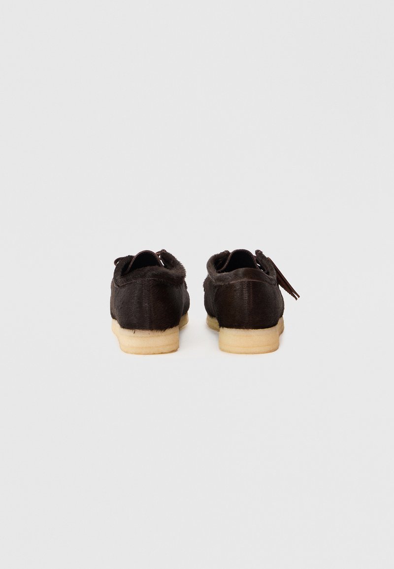 Brown leather shoes with a soft, textured finish, featuring a rounded toe and a light-colored rubber sole. No visible embellishments.