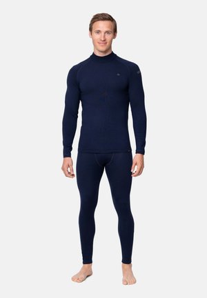 Marinblå termisk baslager-set, med hög krage och långa ärmar, tillverkat av strukturerat, figurnära material, bärs med barfota.