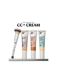 Trzy tubki It Cosmetics CC+ Cream w różnych odcieniach z dwustronnym pędzlem do makijażu na półce, oznaczone "Pairs Perfectly with CC+ CREAM."