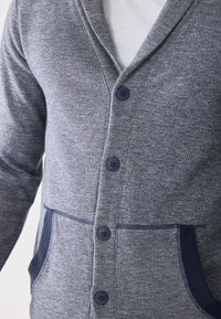 Gray cardigan made of knit fabric, featuring a V-neck, five dark buttons, two front pockets with blue accents, and ribbed cuffs.
