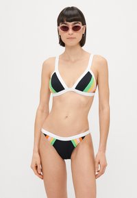 Juodas bikinis su trikampio formos puodeliais ir baltais akcentais, kurio apatinėje dalyje yra daugiaspalvių dryžių akcentų: žalia, oranžinė ir rožinė.