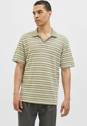 Kortærmet polo-shirt med V-hals, stribet mønster i lysegrøn og creme, lavet af tekstureret stof.