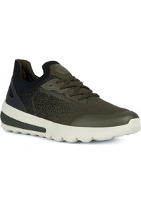 Zapatilla deportiva de color verde oscuro con parte superior de punto texturizado, puntera reforzada, diseño de cordones y suela gruesa de goma blanca.