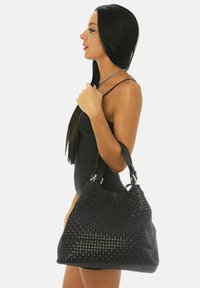 Svart vävd läderhandväska med dubbla handtag, med en texturerad yta och en rymlig, slapp silhuett. Silverfärgade detaljer.