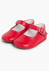 Zapatos Mary Jane de cuero rojo con punta redonda, detalle en forma de ondas a lo largo del borde y una correa con hebilla para un ajuste seguro.