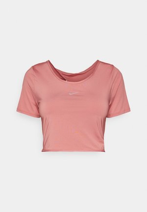 Top sportivo corto a maniche corte rosa con scollo rotondo e piccolo logo Nike bianco al centro del petto.