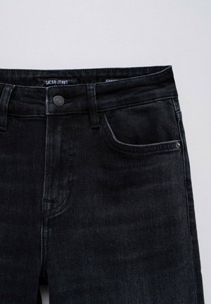 Czarne jeansy o prostym kroju wykonane z denimu, z zapięciem na guzik, przednimi kieszeniami i subtelnymi detalami w okolicy pasa.