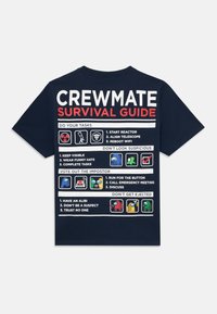 Granatowy t-shirt z grafiką „Przewodnik przetrwania dla załogi” z białym i czerwonym tekstem, ikonami i listami zadań nadrukowanymi na plecach.
