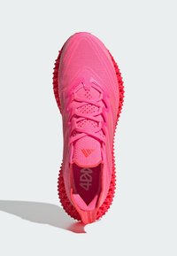 Scarpa sportiva di colore rosa brillante con tomaia in tessuto a rete, lacci texturizzati e suola in gomma audace con punte per trazione. Design leggero.