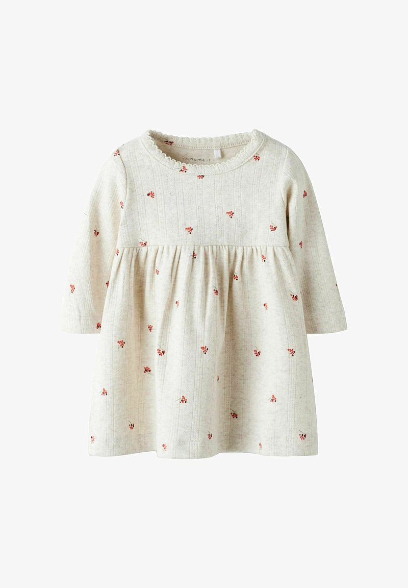 Robe pour bébé à manches longues de couleur crème avec de petites imprimés floraux rouges et un col rond à bord festonné.