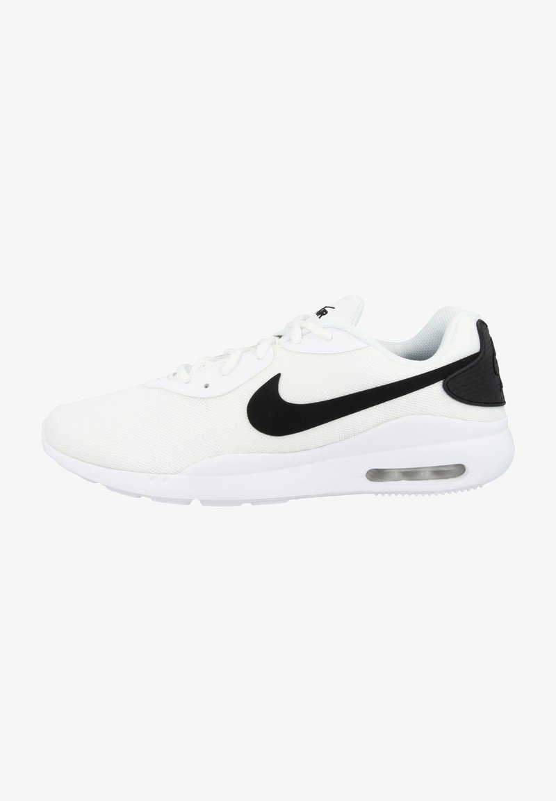 Baskets blanches de sport avec logo Nike swoosh noir et amorti à air visible dans la semelle, vues de l'extérieur.