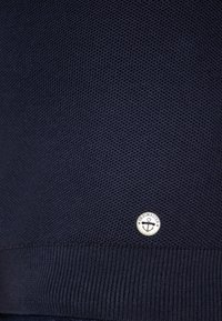 Pulover tricotat de culoare bleumarin, cu un material texturat și un tiv cu dantelă. Include un buton cu tonalitate argintie având un design cu ancoră.