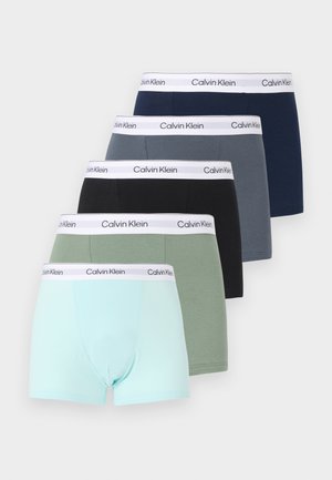 Πέντε ζευγάρια ανδρικά μπόξερ Calvin Klein σε ανοιχτό μπλε, πράσινο, μαύρο, γκρι και ναυτικό μπλε, στοιβαγμένα το ένα πίσω από το άλλο.
